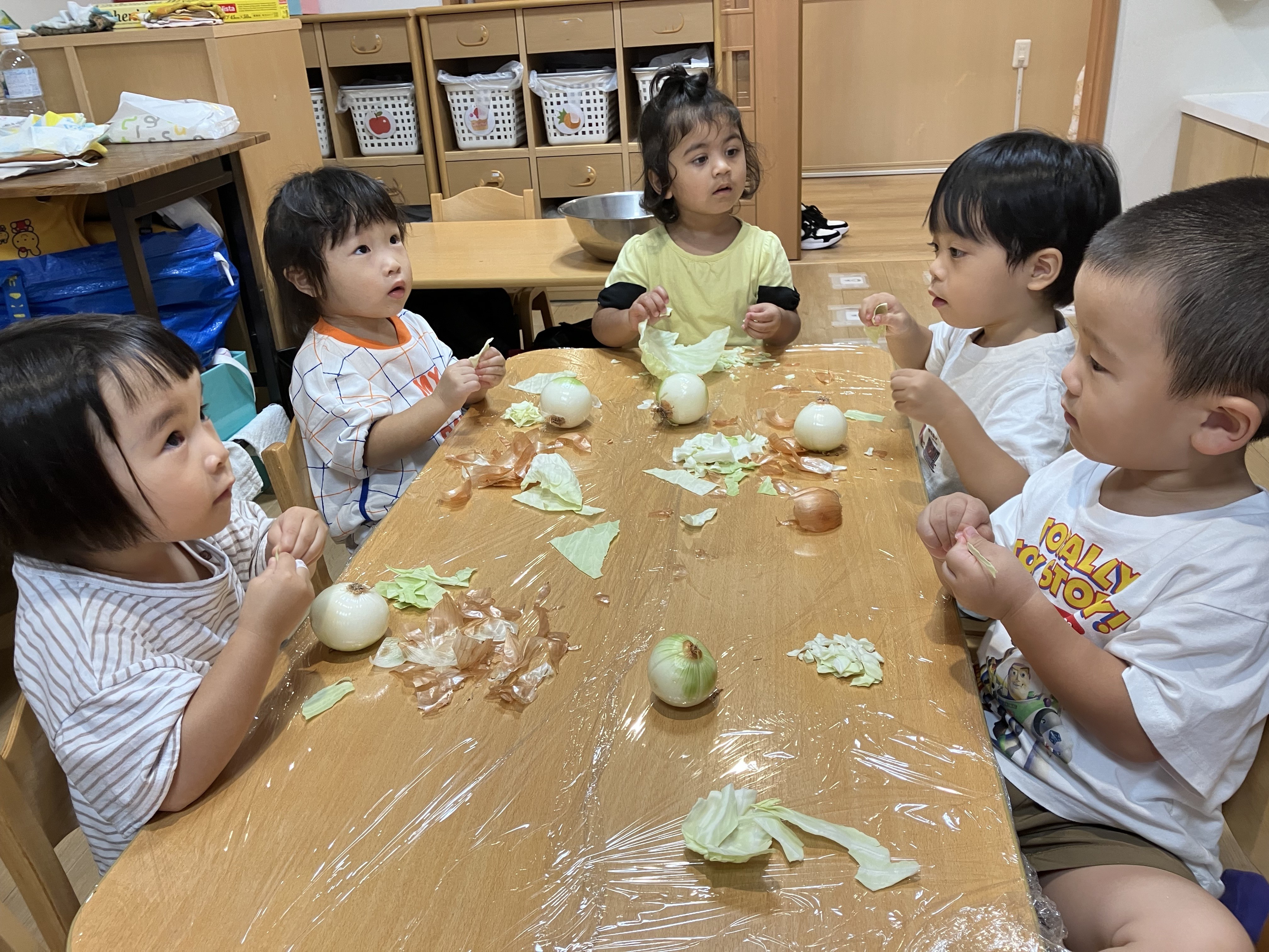 2歳児しずく組　食育「玉ねぎ皮むき/キャベツちぎり」