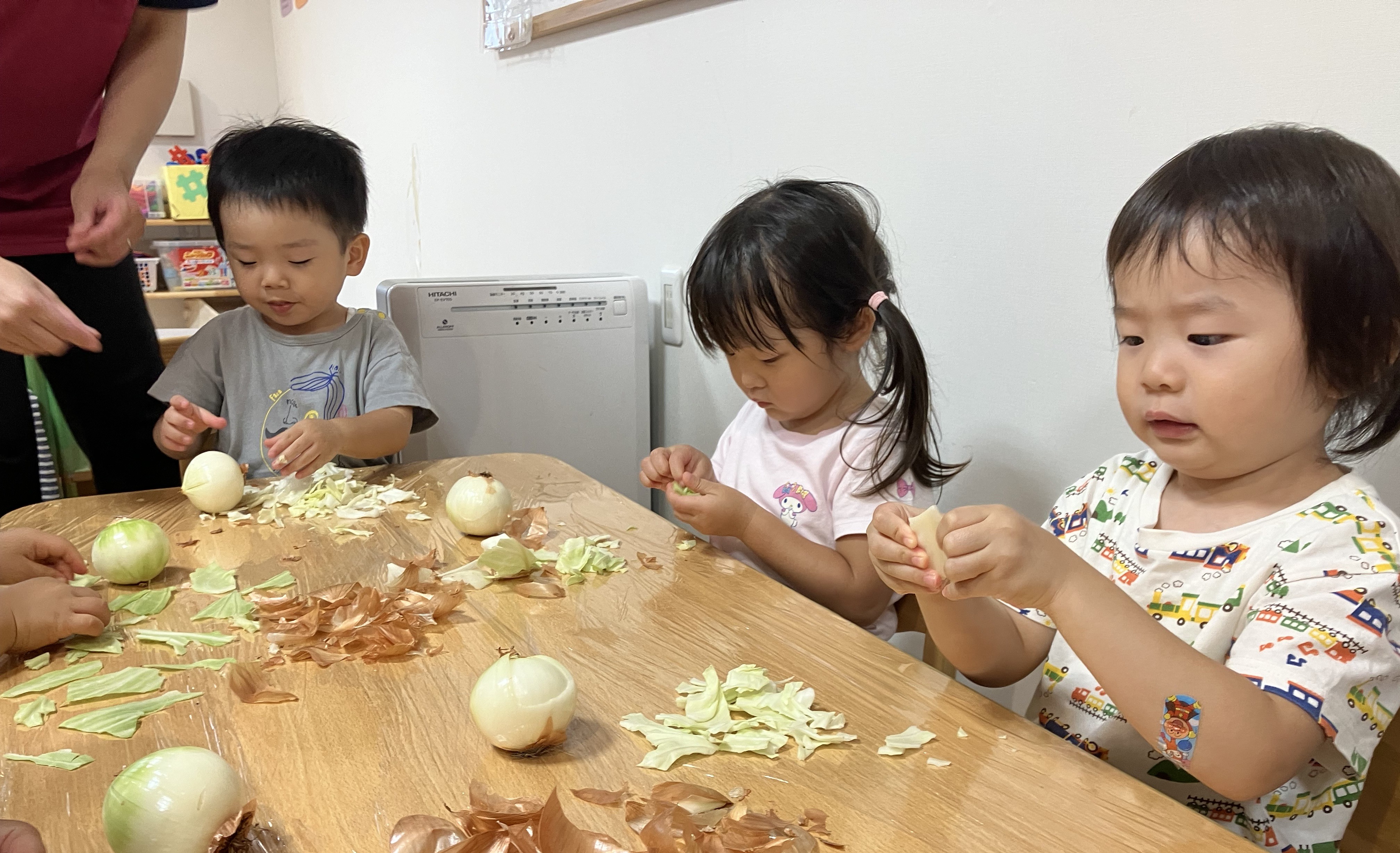 2歳児しずく組　食育「玉ねぎ皮むき/キャベツちぎり」